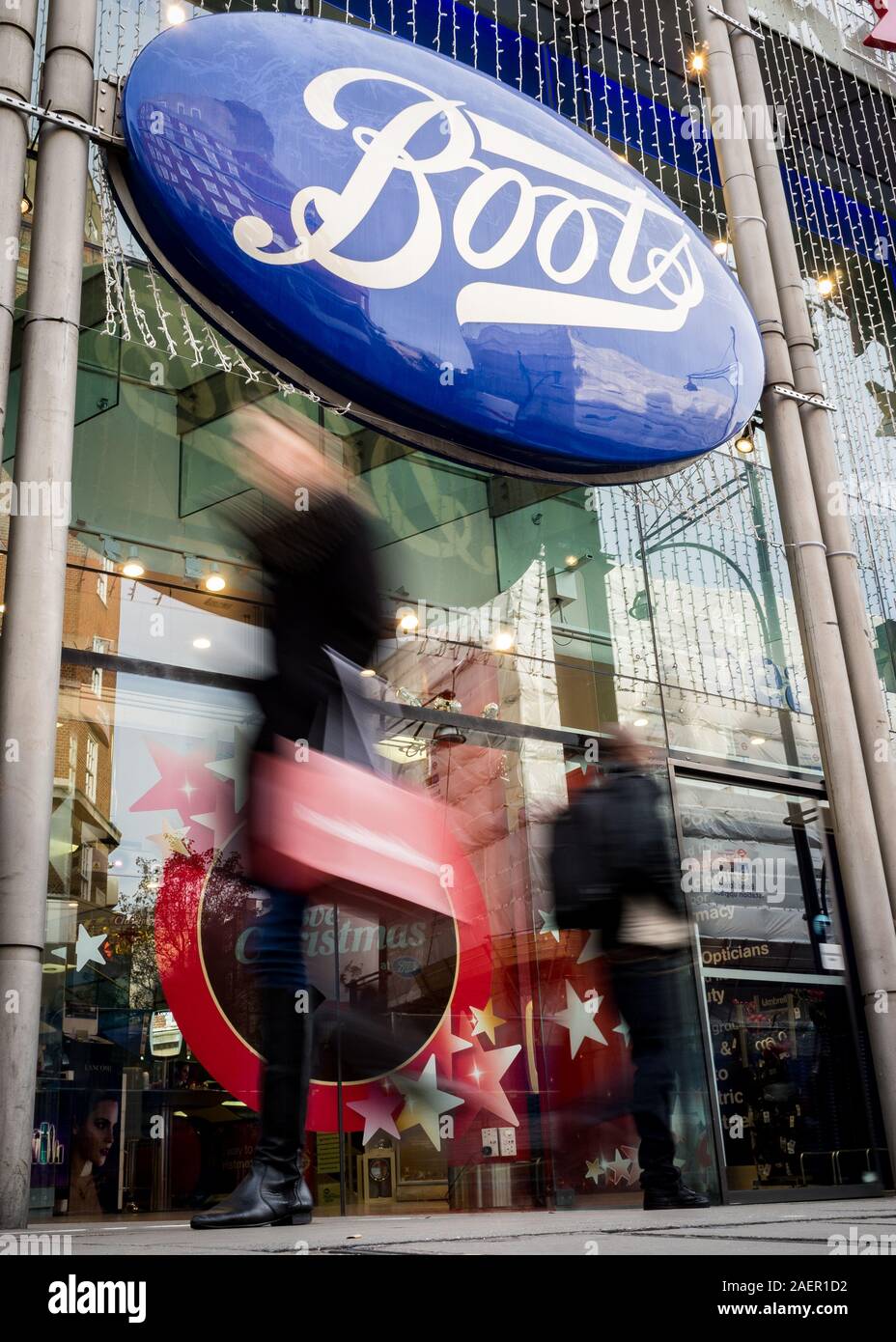 LONDON, Großbritannien - 23 November 2011: Stiefel der Chemiker. Verschwommen Käufer zu Fuß vorbei an der shop Front die Stiefel Store auf der Londoner Oxford Street. Stockfoto