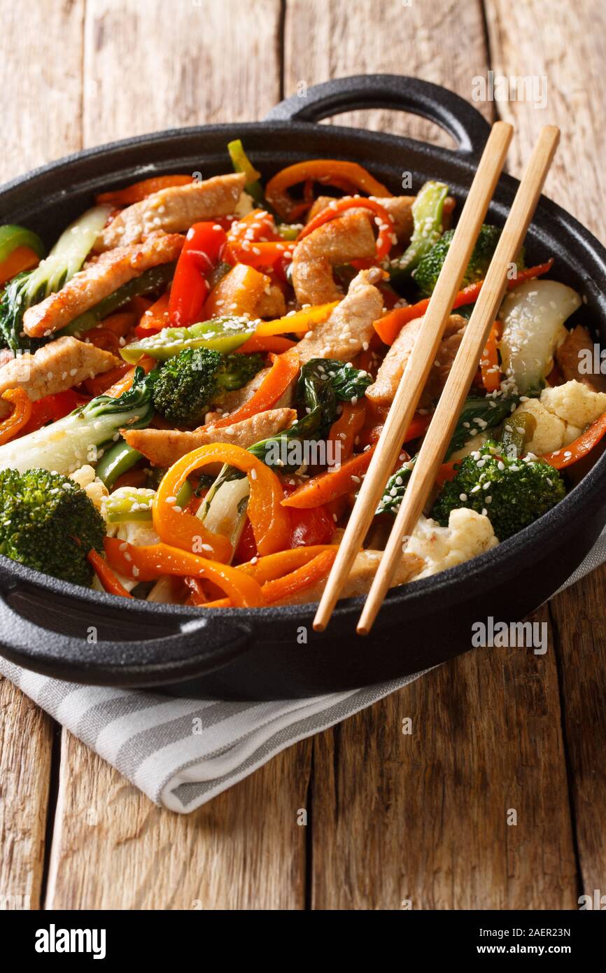 Chinesische braten Schweinefilet mit Broccoli, Bok Choy, Karotten, Paprika,  Blumenkohl close-up in einer Pfanne auf dem Tisch. Vertikale  Stockfotografie - Alamy