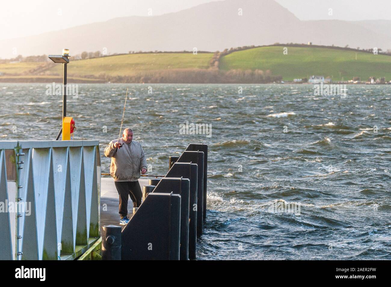 Bantry, West Cork, Irland. Trotz Windstärke Wind und rauer See in Bantry Harbour, dieser Herr war auf einem Ponton angeln bei Flut an diesem Nachmittag. Met Éireann issud ein Gelber Wind Warnung für ganz Irland heute morgen. Credit: Andy Gibson/Alamy Leben Nachrichten. Stockfoto