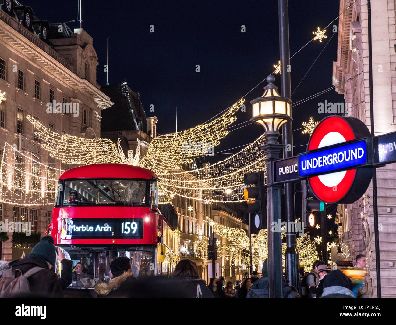 REGENT STREET WEIHNACHTSBELEUCHTUNG Menschen Weichzeichner mit Red London Bus Weihnachtskäufer und London U-Bahn Eingang zur U-Bahnstation Piccadilly London UK Stockfoto