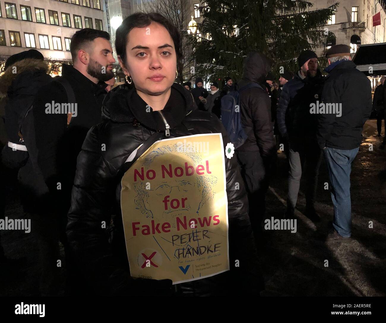 10 Dezember 2019, Schweden, Stockholm: Halima Subasic zeigt auf der Norrmalmstorg mit einem Papier mit der Aufschrift "Kein Nobelpreis für gefälschte Nachrichten" gegen die Verleihung des Nobelpreises für Literatur 2019 an den österreichischen Schriftsteller Peter Handke wegen seiner umstrittenen Position in der jugoslawischen Konflikt. Foto: Steffen Trumpf/dpa Stockfoto