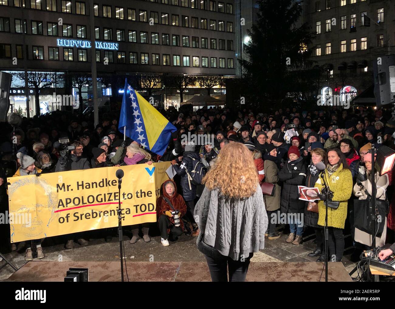 10 Dezember 2019, Schweden, Stockholm: Menschen demonstrieren auf der Norrmalmstorg mit einem Banner mit der Aufschrift "Mr. Handke, heute entschuldigen für die Opfer von Srebrenica gegen die Verleihung des Nobelpreises für Literatur 2019 an den österreichischen Schriftsteller Peter Handke wegen seiner umstrittenen Position in der jugoslawischen Konflikt. Foto: Steffen Trumpf/dpa Stockfoto