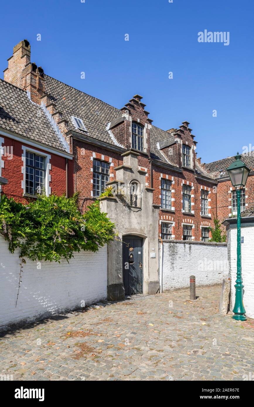 Gasse mit roten Häuser in dem kleinen Beginenhof O.L.V. Ter Hooyen / Unsere Liebe Frau von Ter Hooie/Our-Lady Hooyen in der Stadt Gent, Flandern, Belgien Stockfoto