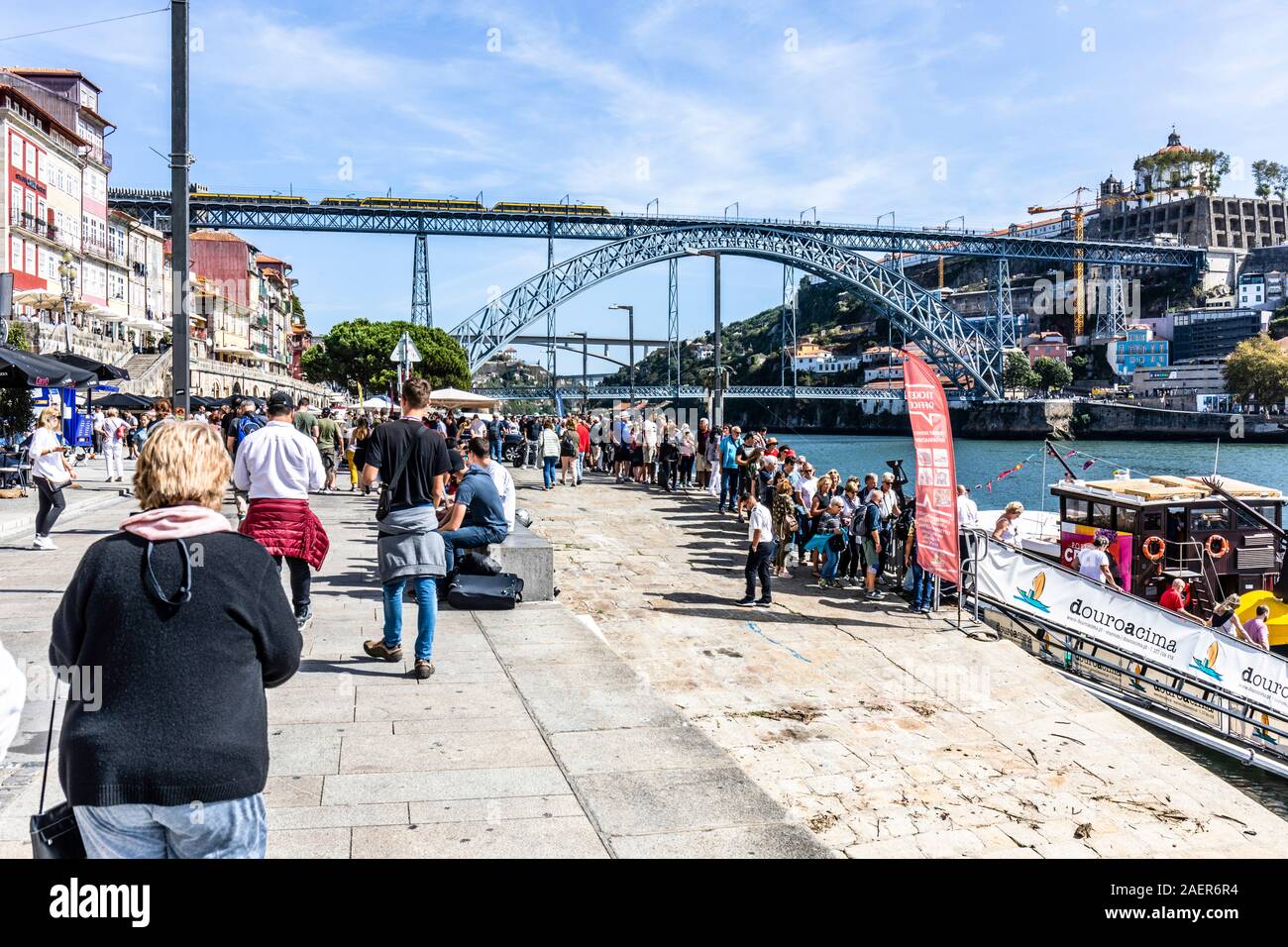 Porto, Nordufer des Douro Flusses ostwärts gegen Luis I Brücke. Touristen Warteschlange Bootsfahrten auf dem Fluss Douro zu nehmen Stockfoto