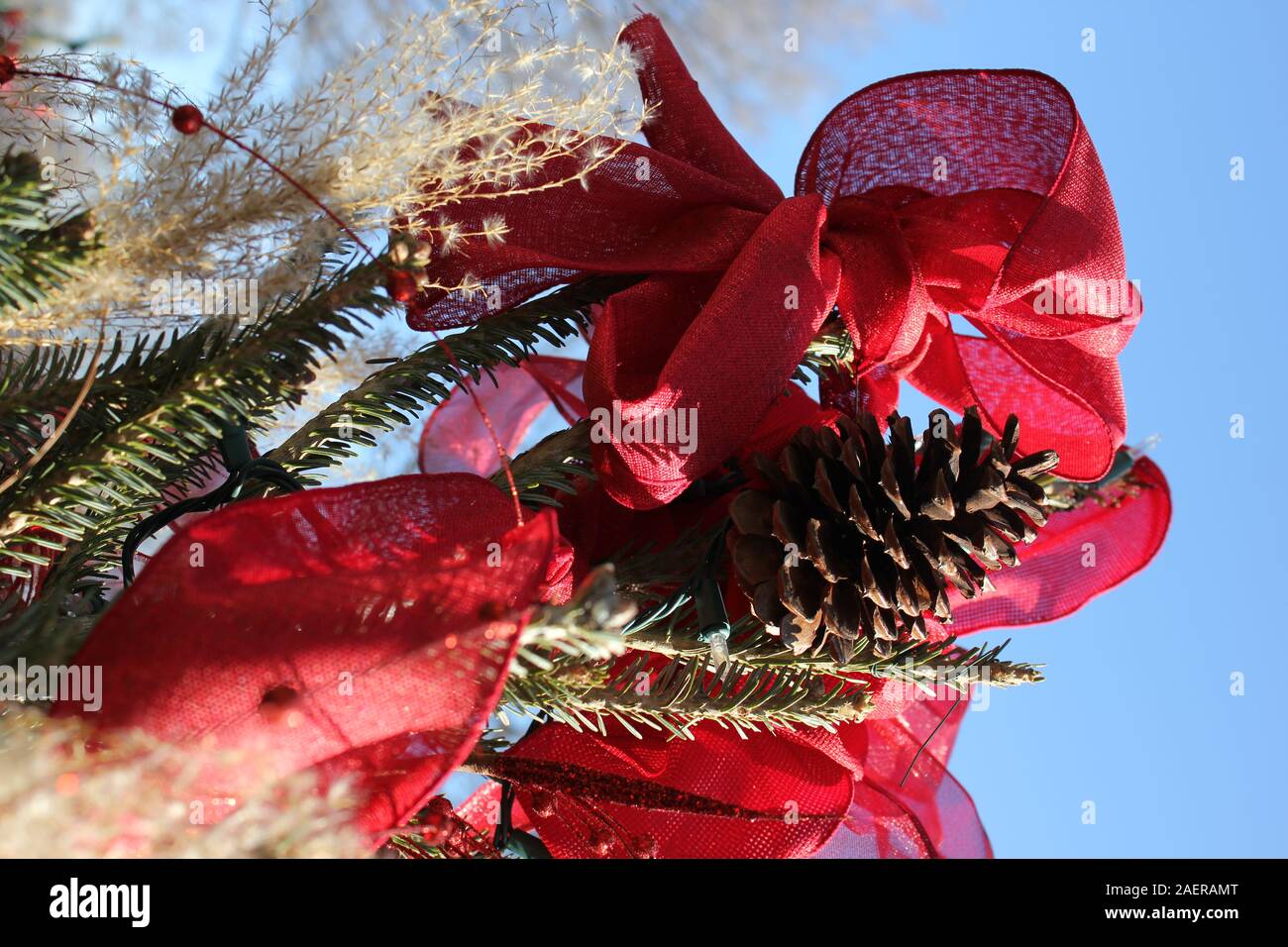 Spaß, festlich, handgefertigten Christbaumschmuck eines eingerichteten winter Pine Cone und einen roten Bogen Stockfoto