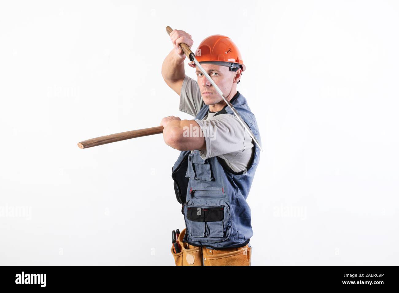 Die Builder zeigt einen Kampf mit einem Katana. Handwerker mit Helm und Arbeitskleidung. Stockfoto