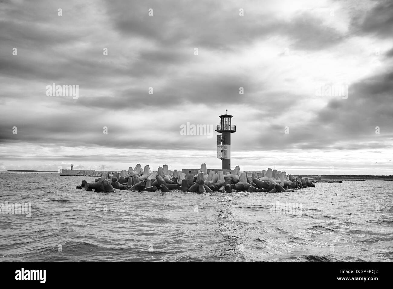 Schwarz-weiß Bild von einem Meer Leuchtturm mit stürmischen Wolken. Stockfoto