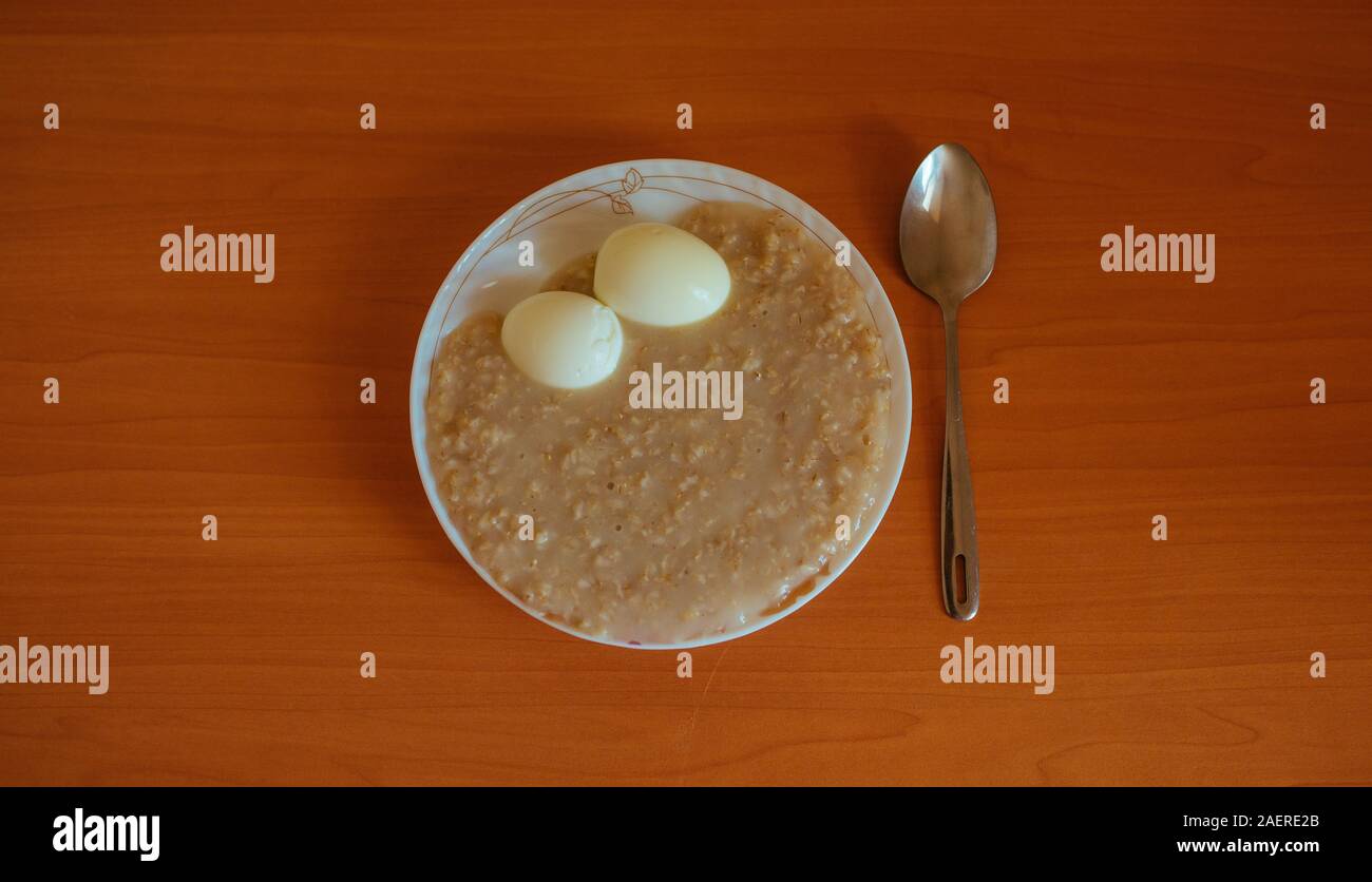 Haferflocken Porridge mit gekochten Eiern, Frühstück auf dem Tisch  Stockfotografie - Alamy