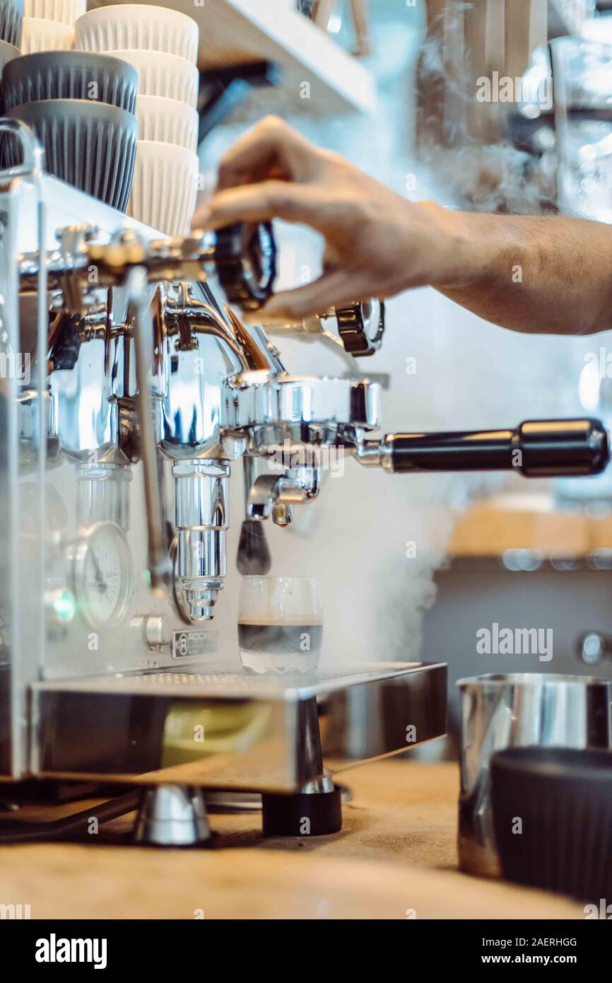 Barista dampft mit Kaffeemaschine im Cafe Stockfoto