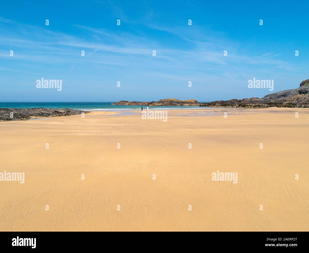 Zwei einsame Figuren Wandern auf herrlichen goldgelben Sandstrand von Kiloran Strand im Sommer, von der Insel Colonsay, Innere Hebriden, Schottland, Großbritannien Stockfoto