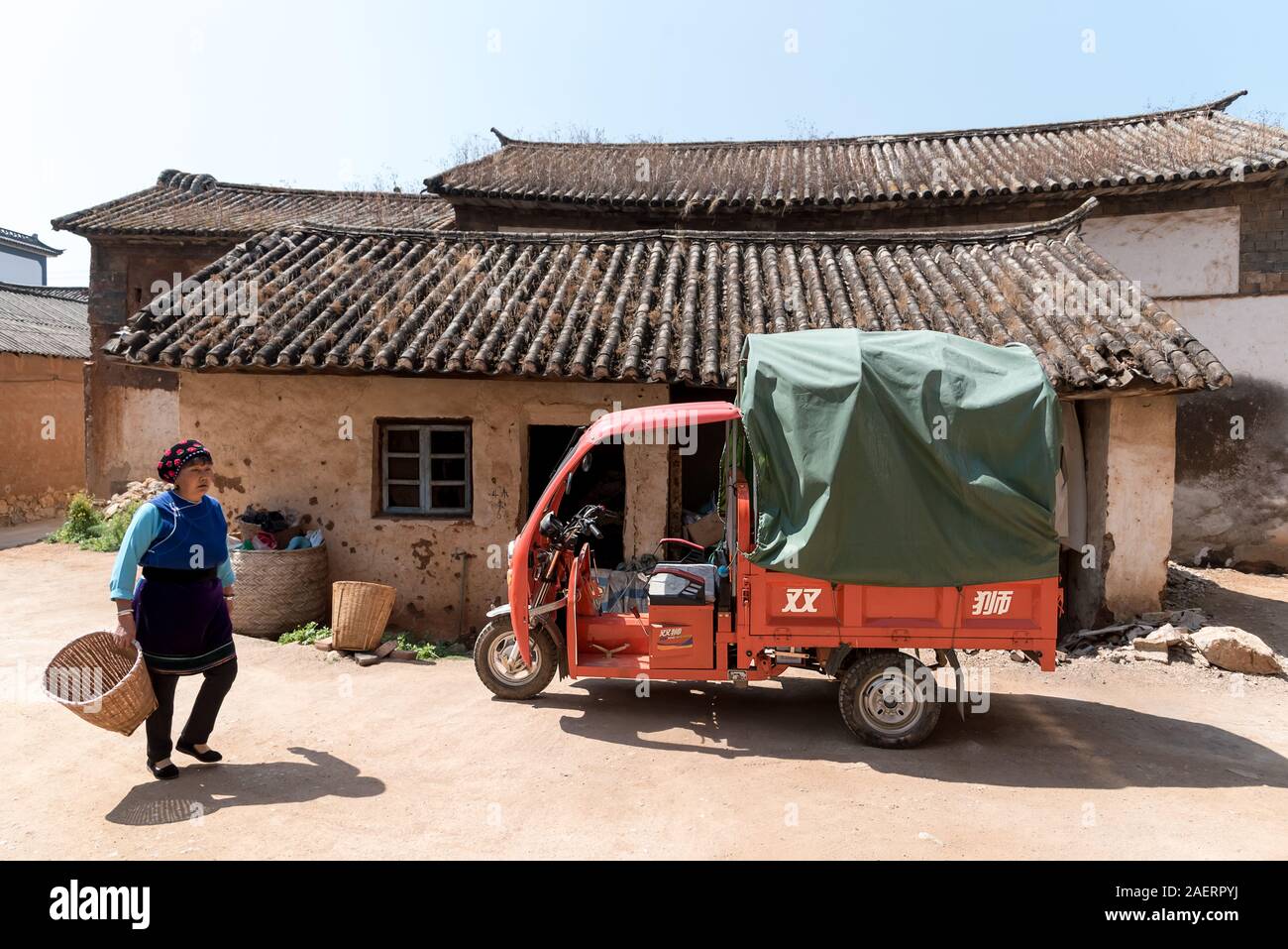 März 13, 2019: Eine ältere Bai ethnische Minderheit Frau wandern in Zhoucheng Dorf, Yunnan, China Stockfoto