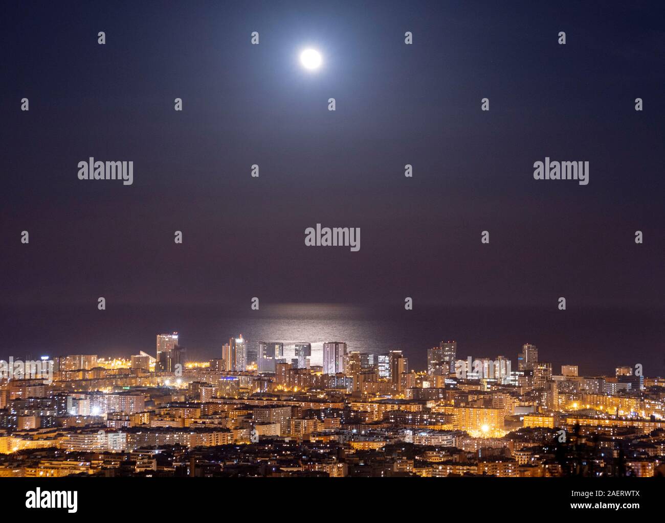 Barcelona Skyline bei Nacht mit dem Mond über dem Meer Stockfoto