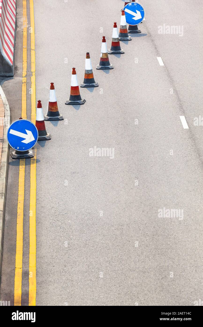 Asphalt detail Hintergrund mit Sicherheit Kegel und Richtungspfeil Zeichen für Spurwechsel bei geschlossenen Straße (Kopie) Stockfoto