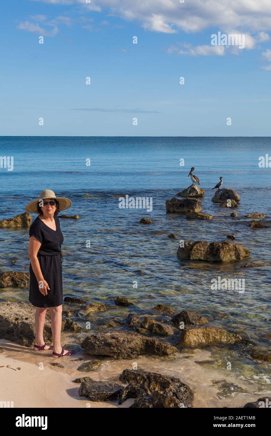 Frau im Urlaub posiert mit einem Pelikan und Freund an der Riviera Maya in Mexiko in der Nähe von Tulum Stockfoto