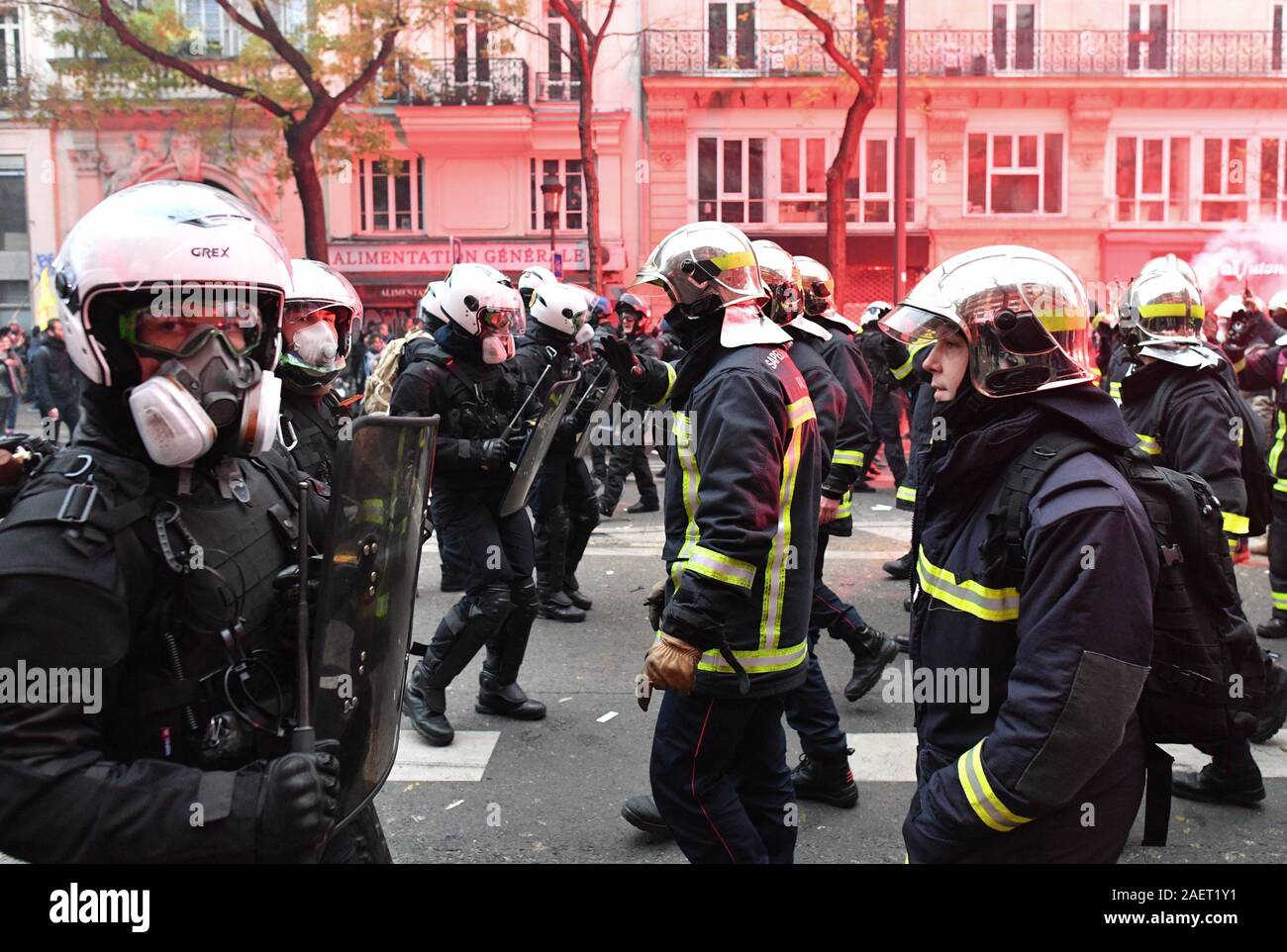 *** Streng KEINE VERKÄUFE IN DEN FRANZÖSISCHEN MEDIEN UND VERLAGE *** Dezember 05, 2019 - Paris, Frankreich: Französische Feuerwehrleute Streik in Richtung der Polizei Linien mit ihren erhobenen Armen nach Auseinandersetzungen stattgefunden hat vor einer Demonstration gegen die Rentenreform der Präsident Emmanuel's Längestrich. Die Polizei zog und lassen Sie die März fortgesetzt. Zehntausende von Menschen demonstrierten in Paris ihren Widerstand gegen das Vorhaben der Regierung zu äußern. Stockfoto