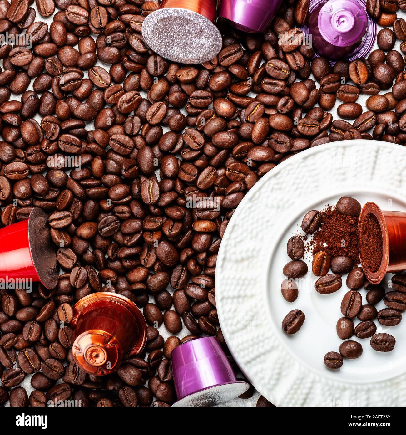 Öffnen Espresso Kaffee Kapseln oder Hülsen und Kaffeebohnen auf grauem Hintergrund, Ansicht von oben Stockfoto
