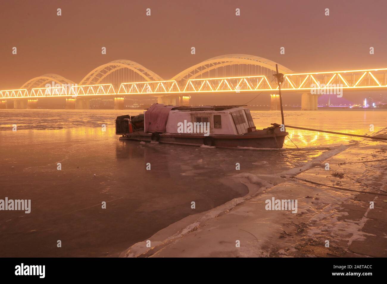 Ein Fischerboot Häfen am Songhua-fluss, das ist der größte Nebenfluss des Flusses Heilongjiang und friert wegen der drastischen Temperaturabfall, Witz Stockfoto