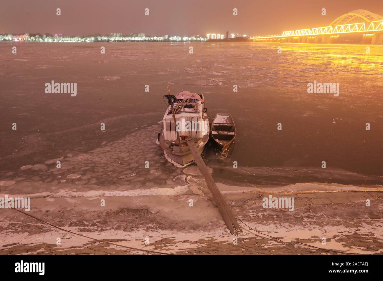 Ein Fischerboot Häfen am Songhua-fluss, das ist der größte Nebenfluss des Flusses Heilongjiang und friert wegen der drastischen Temperaturabfall, Witz Stockfoto