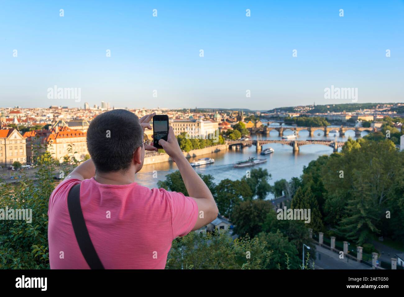 Touristen fotografieren mit Smartphone, Blick auf die Stadt mit Blick auf die Brücken über den Fluss Vltava, Prag, Böhmen, Tschechien Stockfoto
