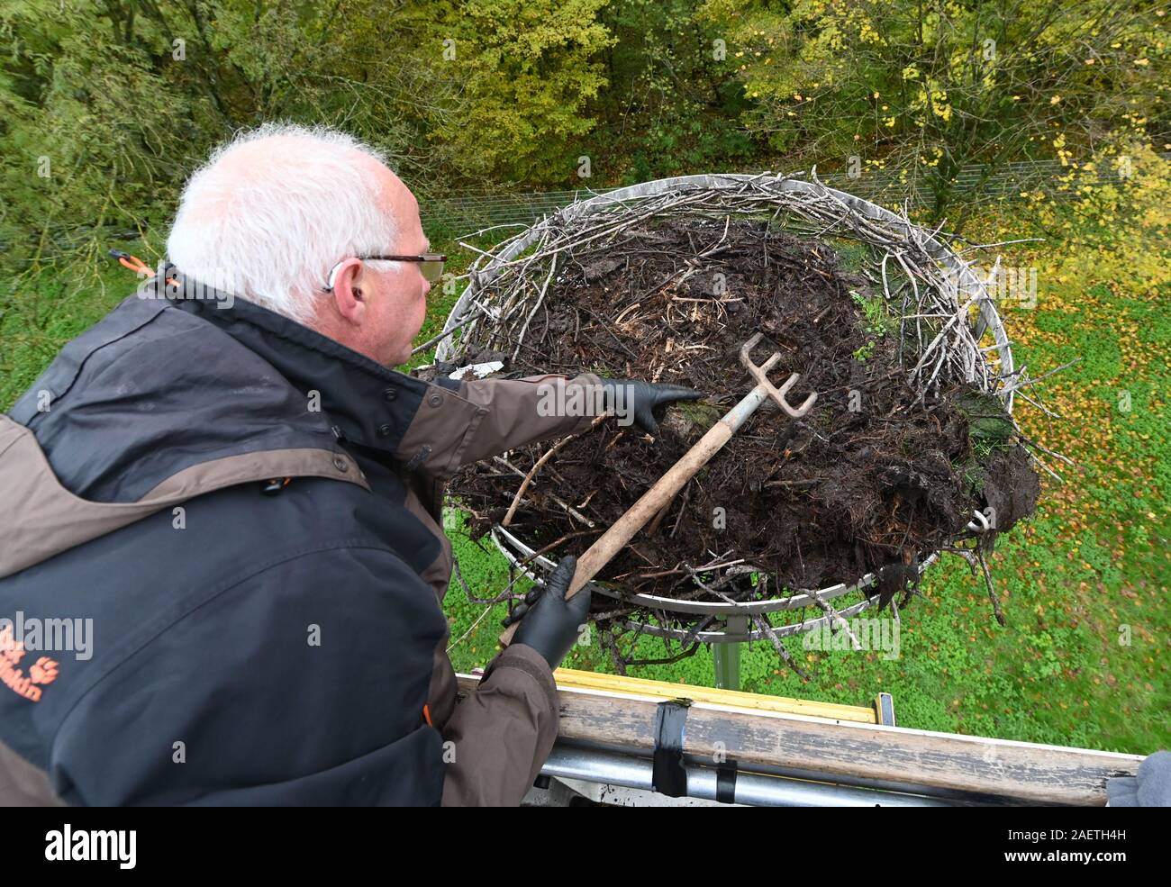 Karlsruhe, Deutschland. Nov, 2019 18. Stefan Eisenbarth reinigt ein Storchennest auf freiwilliger Basis. Kunststoffabfälle insbesondere, die Störche in das Nest als vermeintliche Nahrung oder Nistmaterial, ist schädlich für die Tiere bringen. (Dpa: "Reinigung im Storchennest - Gefahr durch plastik Müll') Credit: Uli Deck / dpa/Alamy leben Nachrichten Stockfoto