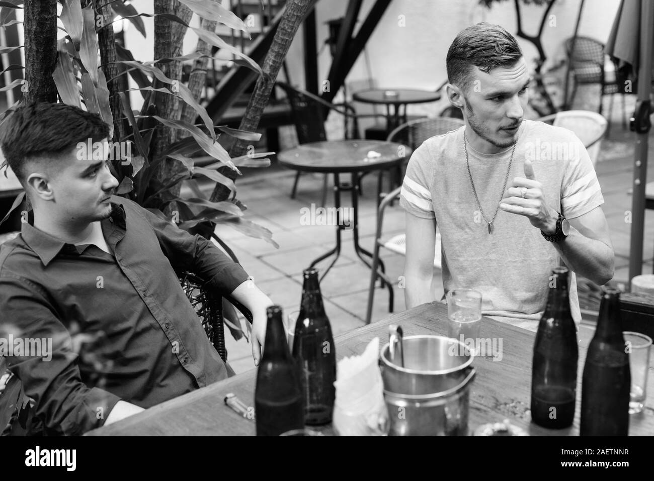 Portrait des jungen Mannes trinken mit Freunden zusammen in den Hinterhof Stockfoto