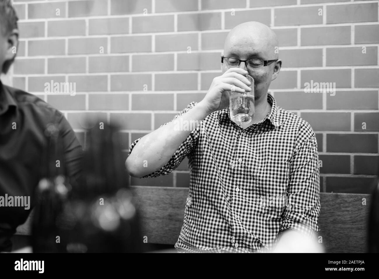 Portrait des jungen Mannes trinken mit Freunden zusammen in den Hinterhof Stockfoto