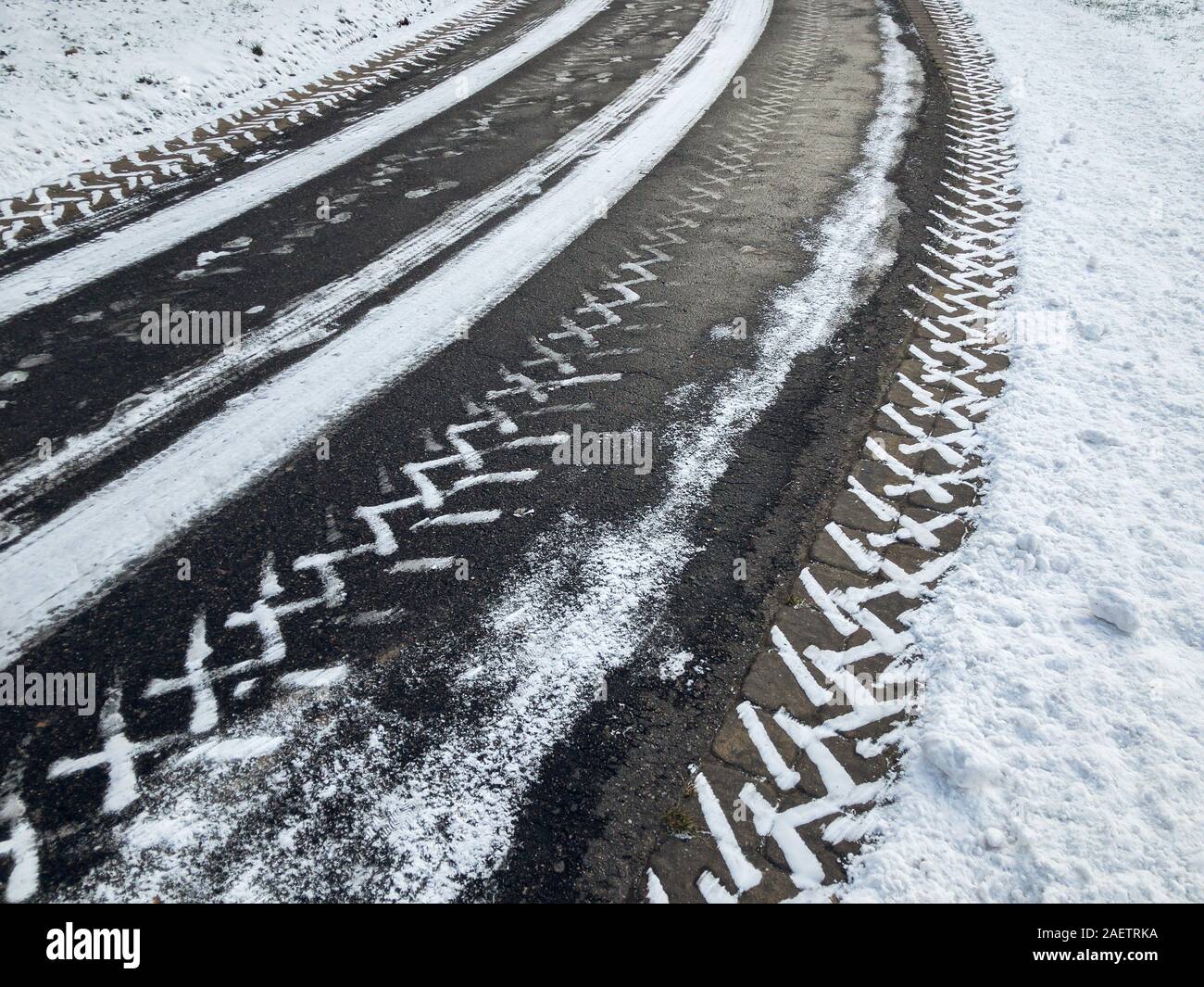 Schneereiche Winter City Road mit Reifen Impressum auf Asphalt Oberfläche Stockfoto