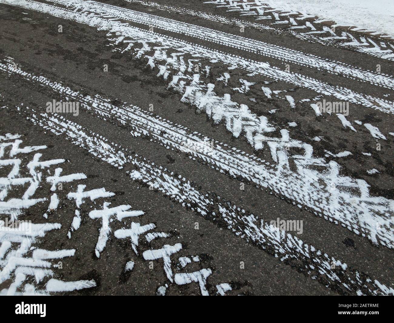 Trace von verschiedenen Reifen auf Asphalt in der Wintersaison Stockfoto