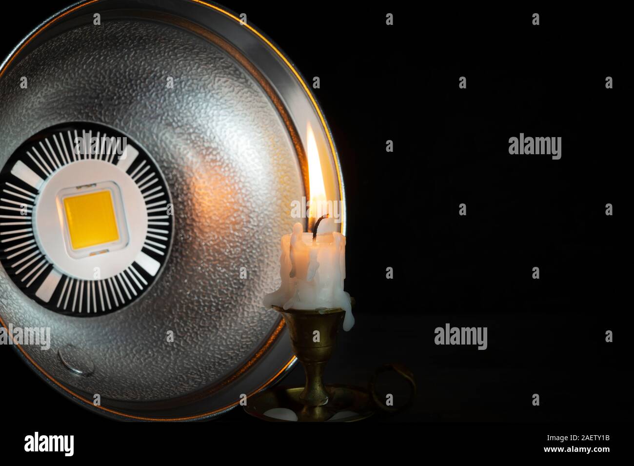 Aus LED-Blitzlicht mit Reflektor bei brennenden Kerze auf vintage Leuchter zeigen, die in der Nähe gesehen - bis auf schwarzem Hintergrund, Maßnahmen der ligh Stockfoto