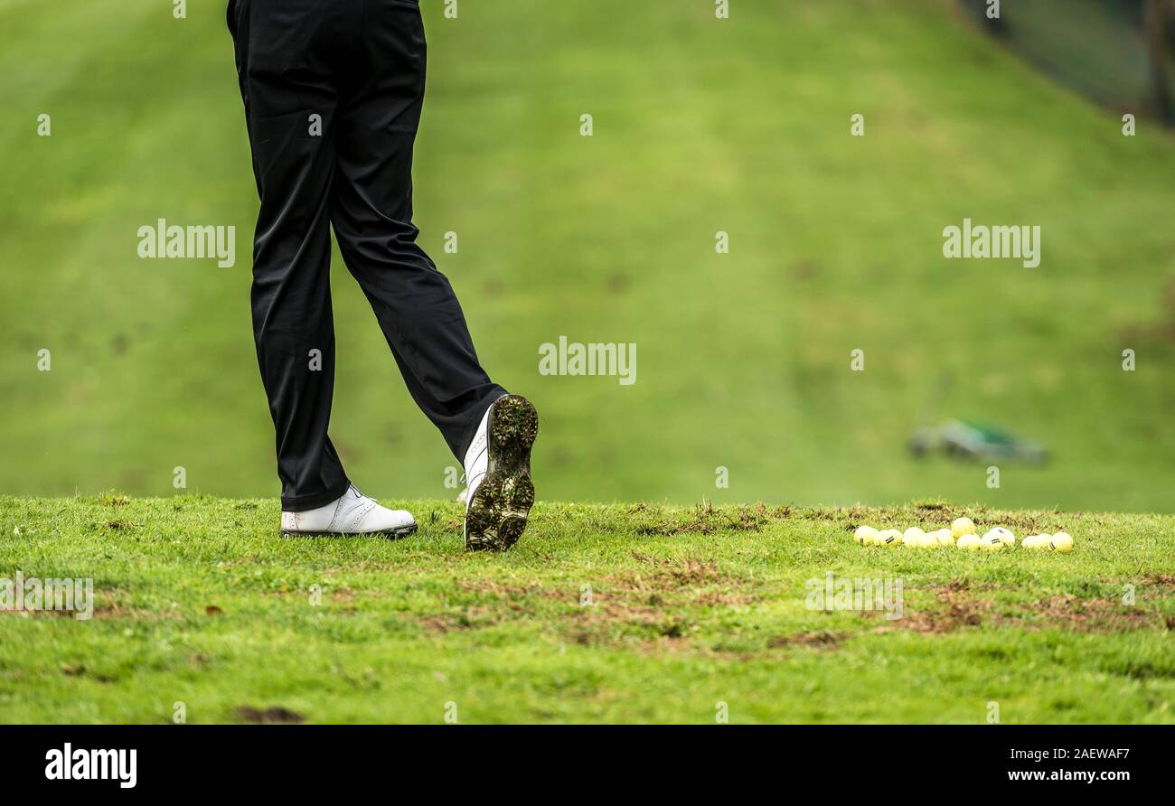 Golfspieler Beine am Golfturnier Praxisschwingen mit Fahrer. Golf Player auf grünen Rasen putting Golf Ball in das Loch. Golf spielende Wettbewerb oder Turnier. Stockfoto