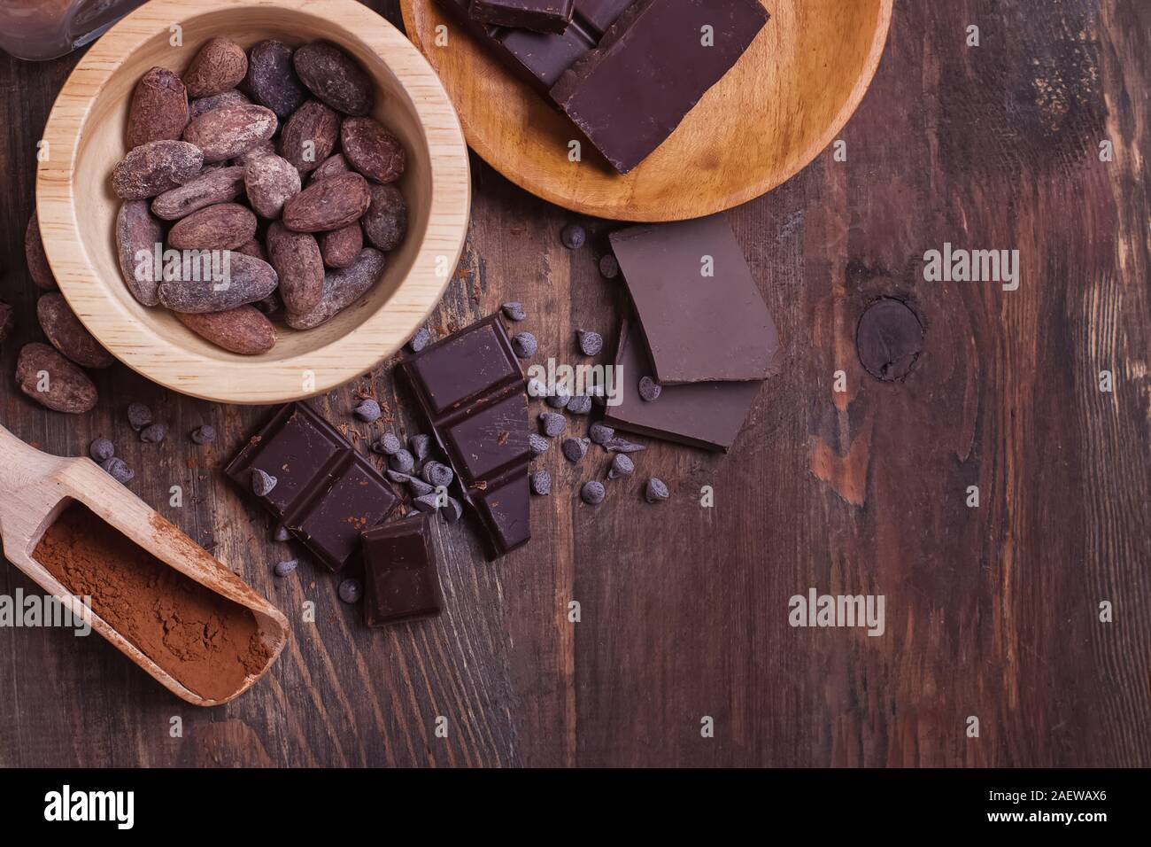 Kakaobohnen und Pulver und Schokoriegel Stücke auf Holz- Hintergrund Stockfoto