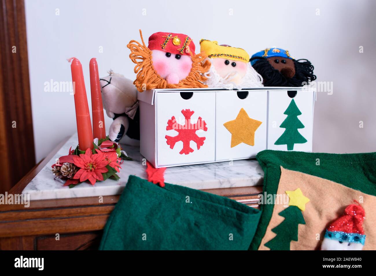 Weihnachtsbaumschmuck close-up. Rote Kerzen mit Blumen. Candy Felder mit den Drei Weisen und Weihnachtssocken für Geschenke. Stockfoto