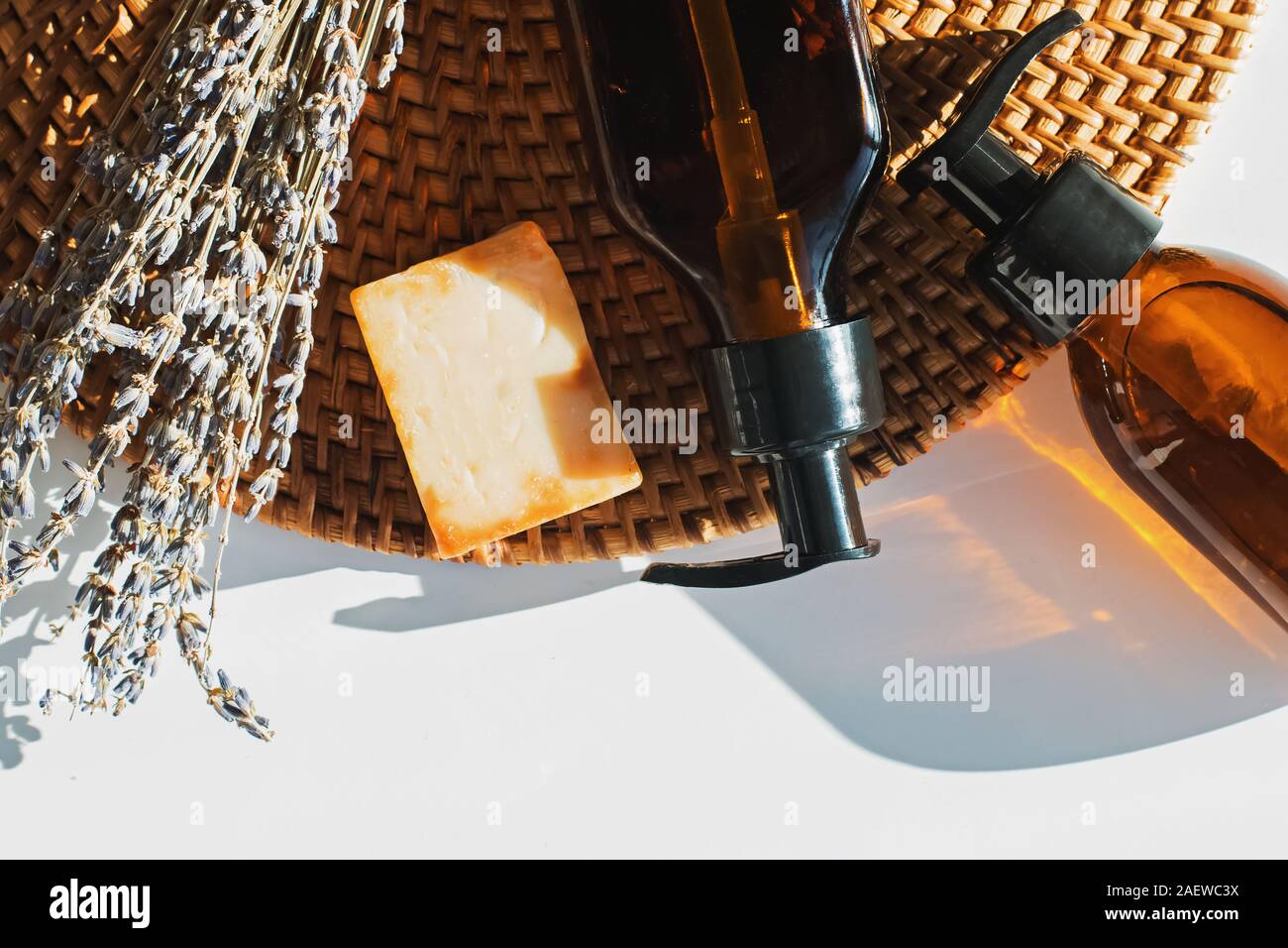 Naturkosmetik mit Lavendel auf Rattan-Matte in natürlichem Sonnenlicht Stockfoto