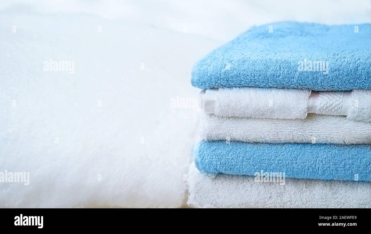 Stapel Handtücher in Weiß und Blau, auf weissem Schnee, isoliert. Classic blau Farbe des Jahres 2020. Stockfoto