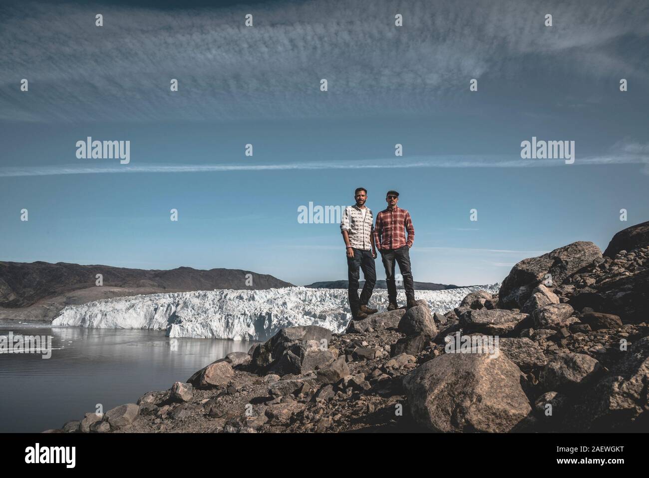 Zwei junge glücklich männlichen Reisenden stand vor der Eqip Sermia Eqi Gletscher in Grönland. Herausfordernde und feindlichen Umwelt. Mehrere Spalten um Stockfoto