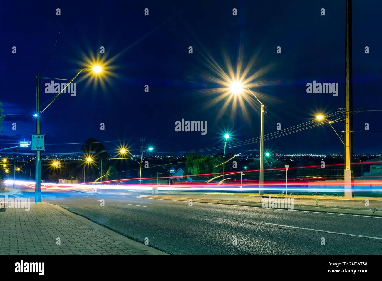 Städtische Straße mit Autos Licht trails unter Straßenlaternen. Speed Concept Stockfoto