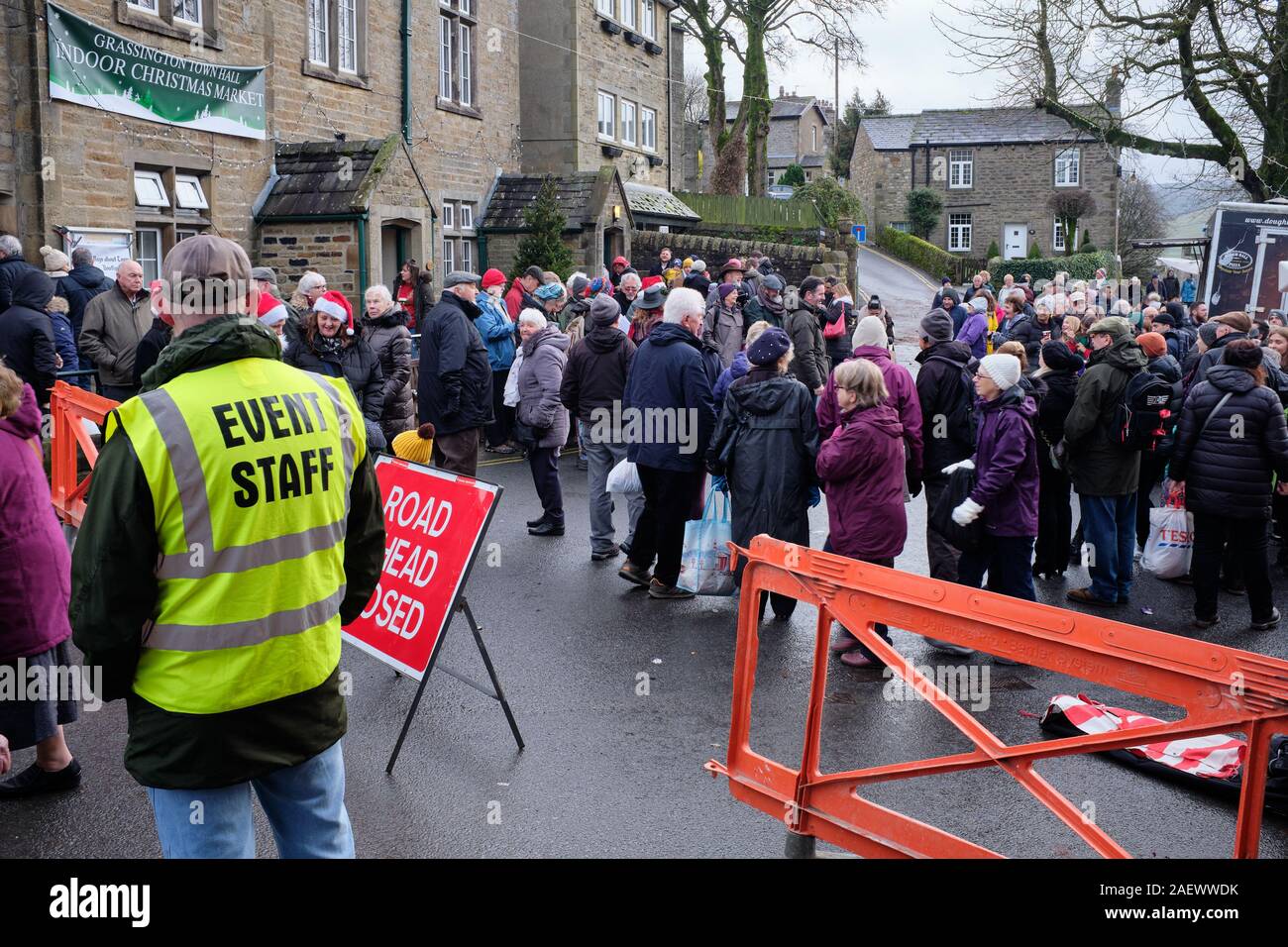 Auf einer feuchten, grauen Nachmittag, Menschenmassen genießen Sie Stände und Lied singen am Dickensian Wochenende an Grassington. 07/12/19. Stockfoto