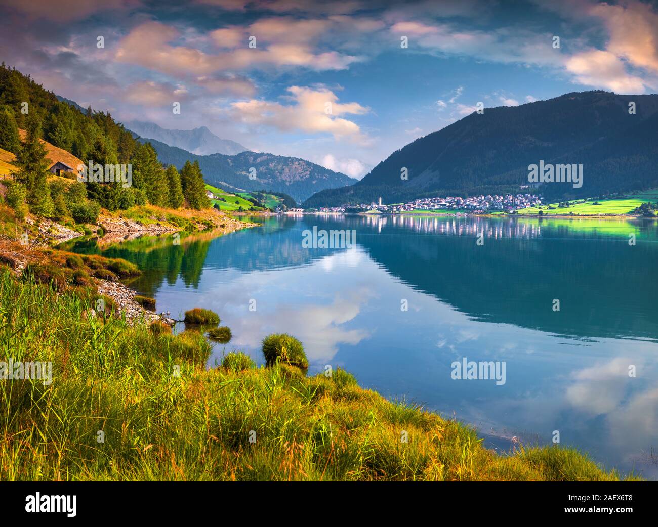 Sonnigen Sommer Szene auf Reschen See. Reschen Dorf im Morgennebel. Alpen, Europa. Region Bozen, Südtirol, Italien, Europa. Stockfoto