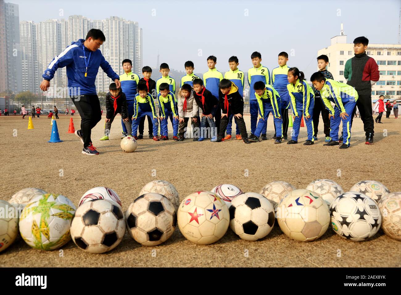 Junge chinesische Studenten Praxis Fußball während einer Schulung und Klasse auf dem Hof einer Grundschule in Lanzhou City, East China Jiangs Stockfoto