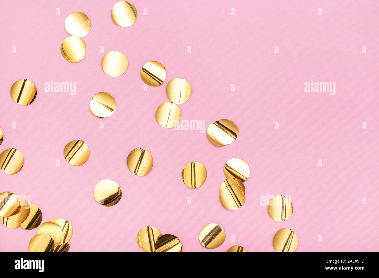 In der Nähe von Gold Metallic Konfetti auf Pastell rosa Hintergrund. Ansicht von oben. Stockfoto