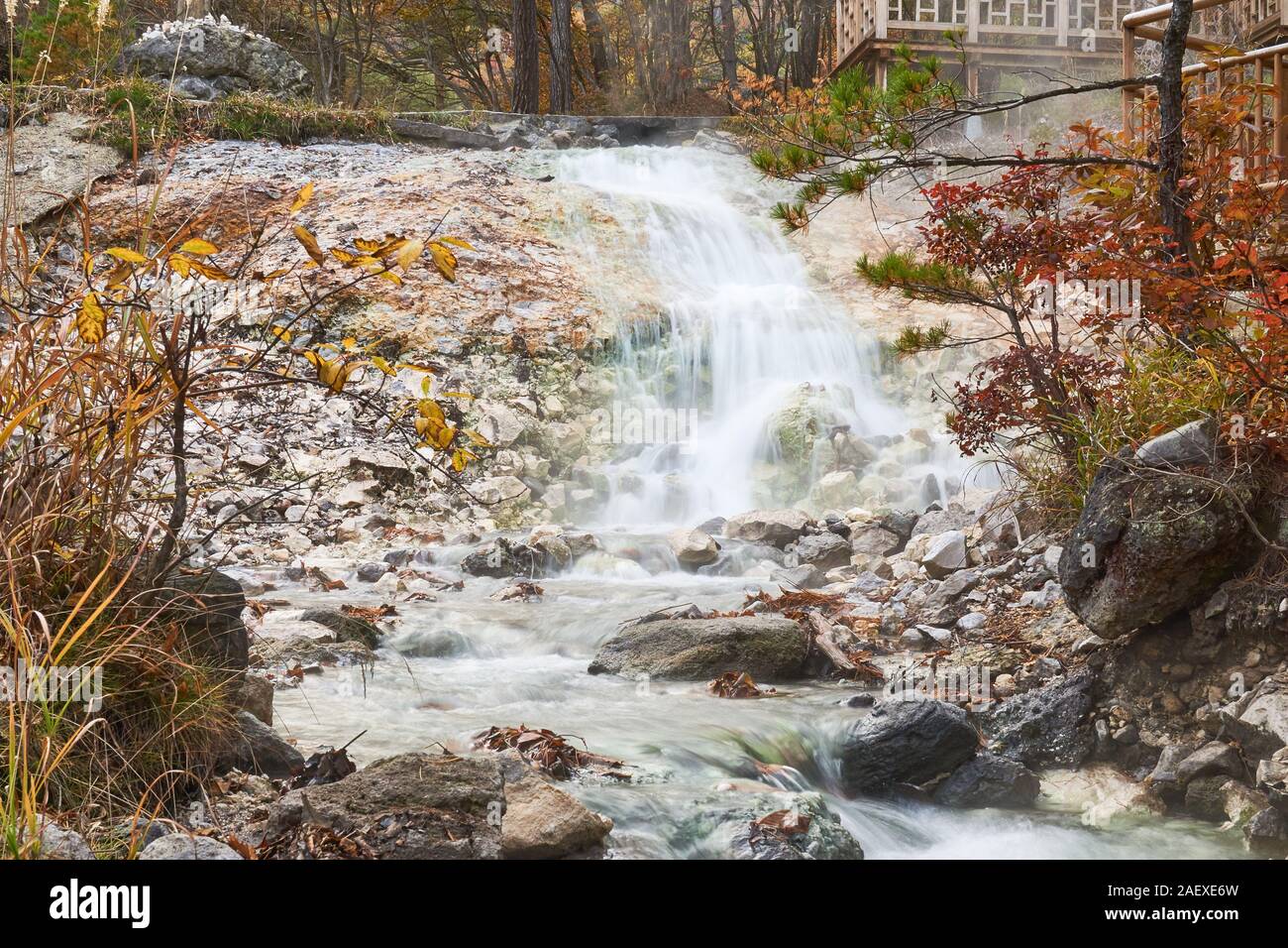 Im Sainokawara Park in Kusatsu, Gunma, Japan, fließt sanft ein heißer Quellwasserfall über Steine. Stockfoto