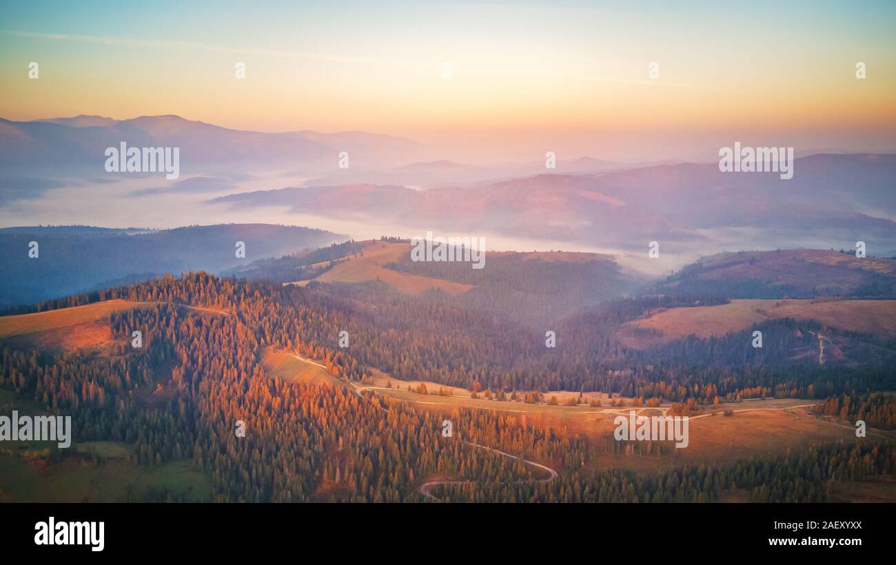Antenne Panorama der wunderschönen Herbst Berge. Sonnenaufgang über Berg nebligen Tal. Misty woodland am Morgen. Karpaten, Ukraine Stockfoto