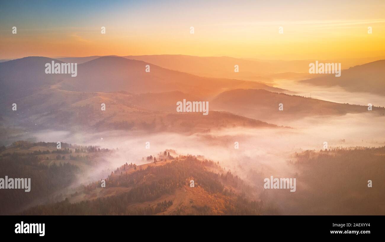Antenne Panorama der wunderschönen Herbst Berge. Sonnenaufgang über Berg nebligen Tal. Misty woodland am Morgen. Karpaten, Ukraine Stockfoto