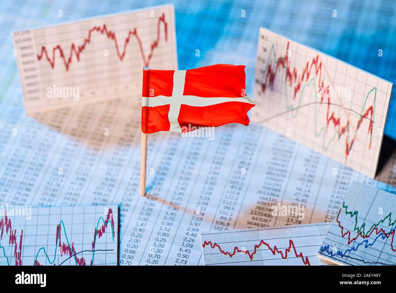 Dänische Flagge mit Kurs Tabellen und Grafiken auf die wirtschaftliche Entwicklung Stockfoto