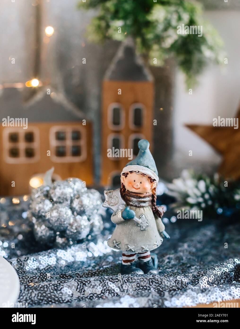 Porzellan Figuren der Kinder in eine weihnachtliche Dekoration. Winter Figuren der ein Junge und ein Mädchen mit den Geschenken, die auf dem Hintergrund der Häuser und Kegel. Weihnachten Stockfoto