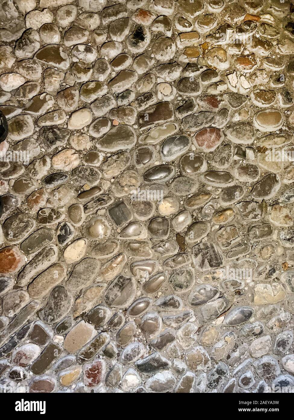 Alten Fußboden aus runden Kieseln aus dem Mittelalter. Bodenbeläge, aus ausgewählten und von Hand sortiert, Steine, Mörtel, mit intensiven Anzeichen von Verschleiß auf. Stockfoto