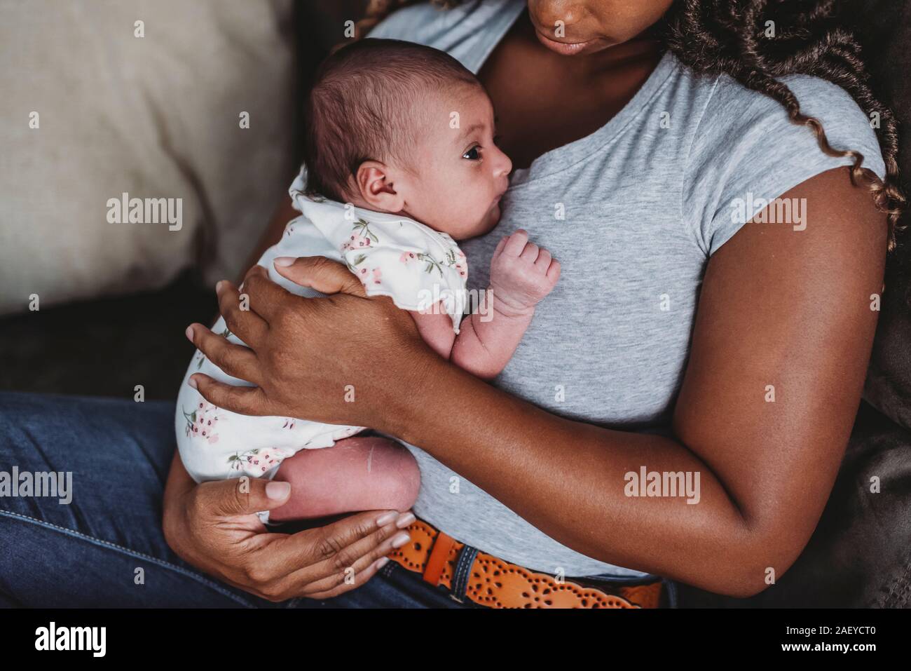 Schwarze Mama im blauen Hemd Holding multirassischen Neugeborene Stockfoto