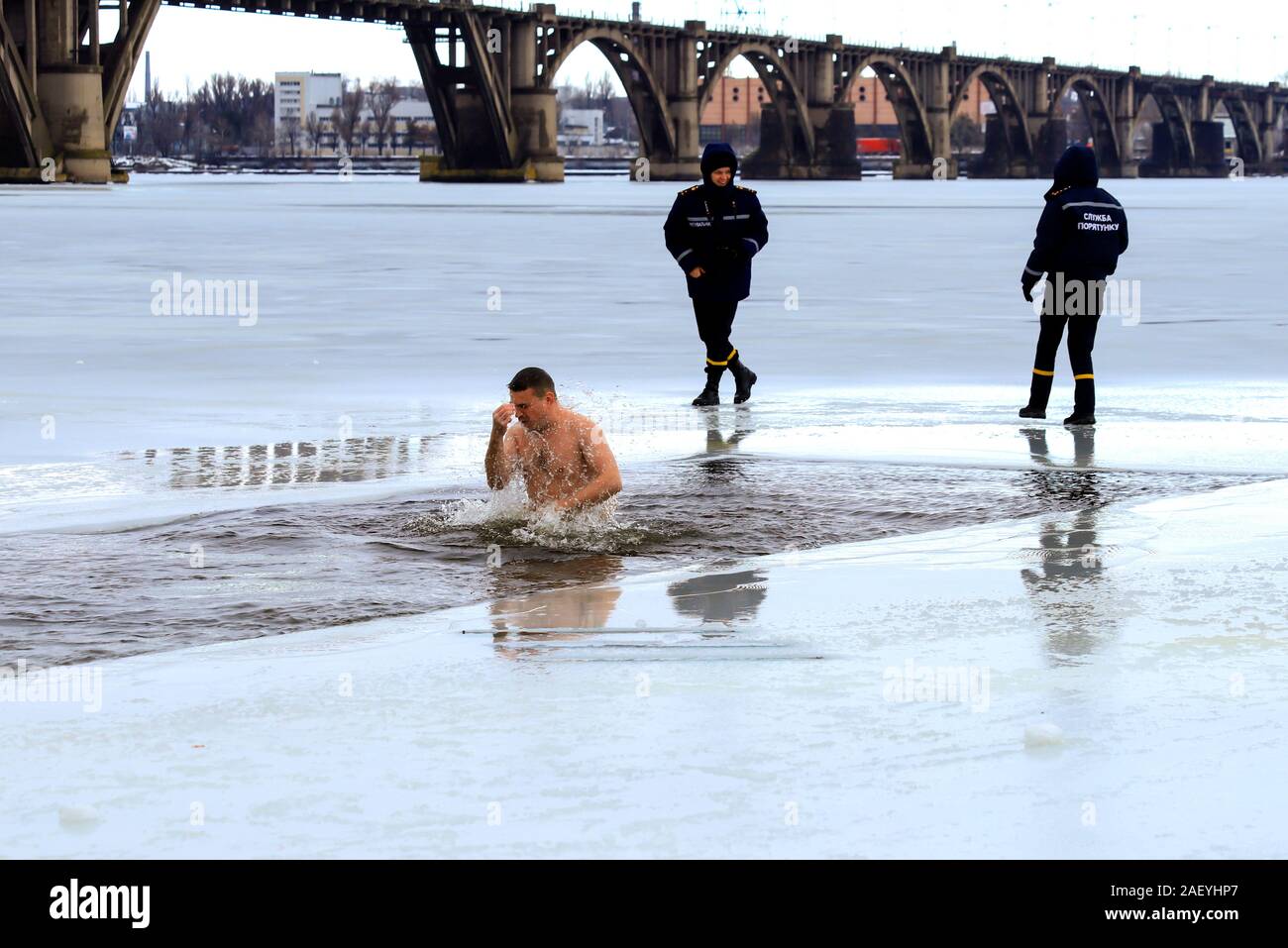 Dnepropetrovsk, Ukraine, 019.01.2019 Wintersport, Schwimmen, Härten. Die Menschen Baden im Fluss unter der Aufsicht von Rettungsschwimmern in Uniform. Stockfoto