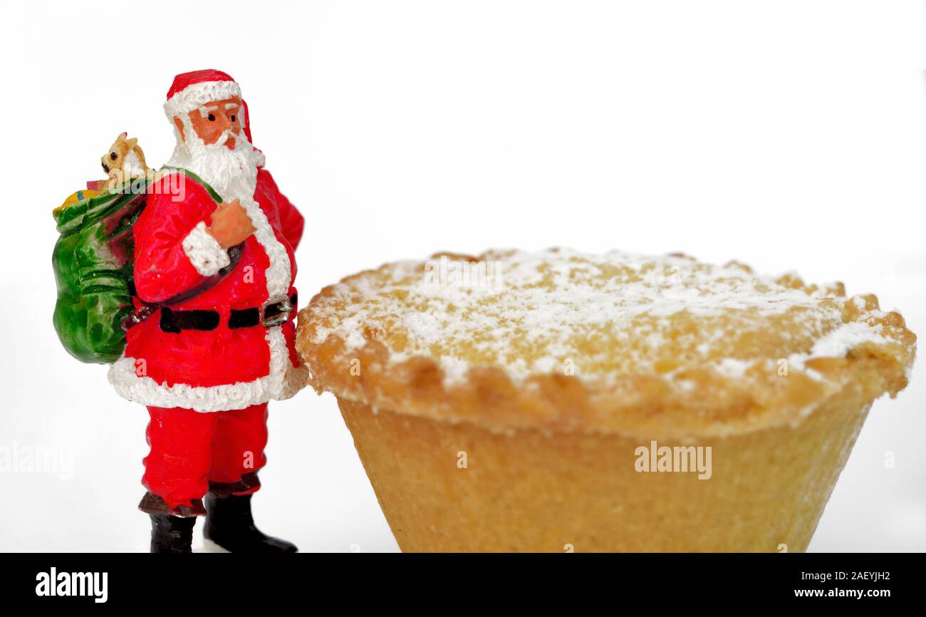 Santa Claus Figur steht neben einer tiefen gefüllt Weihnachten Mince Pie Stockfoto