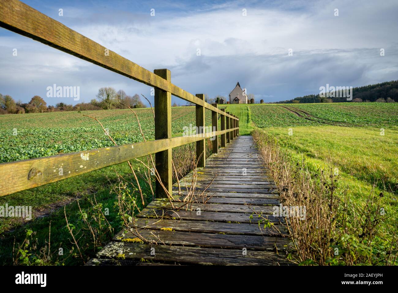 Ein holzzaun und der Weg zu einer ländlichen Kirche auf einem Hügel, St Huberts Kirche, Idsworth, Hampshire Stockfoto